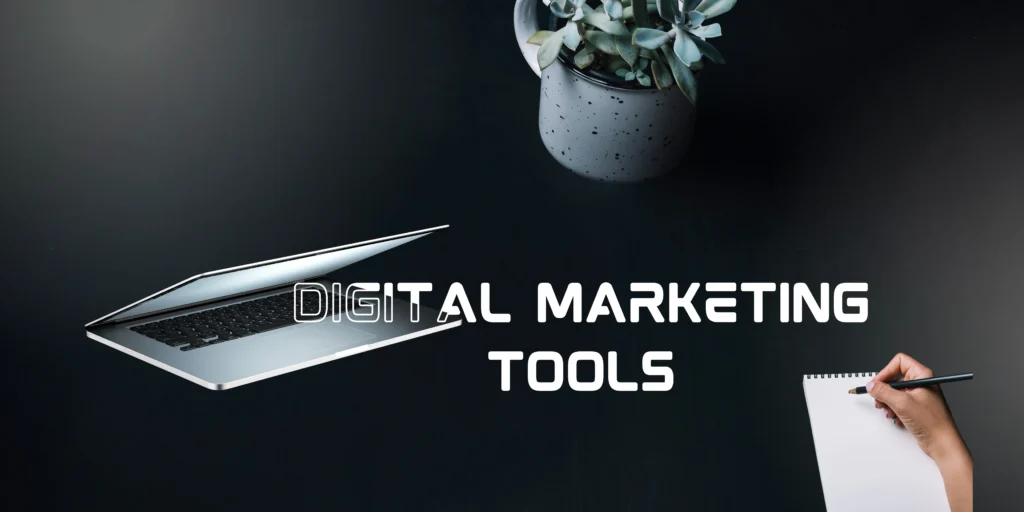 A laptop, a hand writing on a notepad, and a plant on a dark desk with the text "digital marketing tools" overlayed